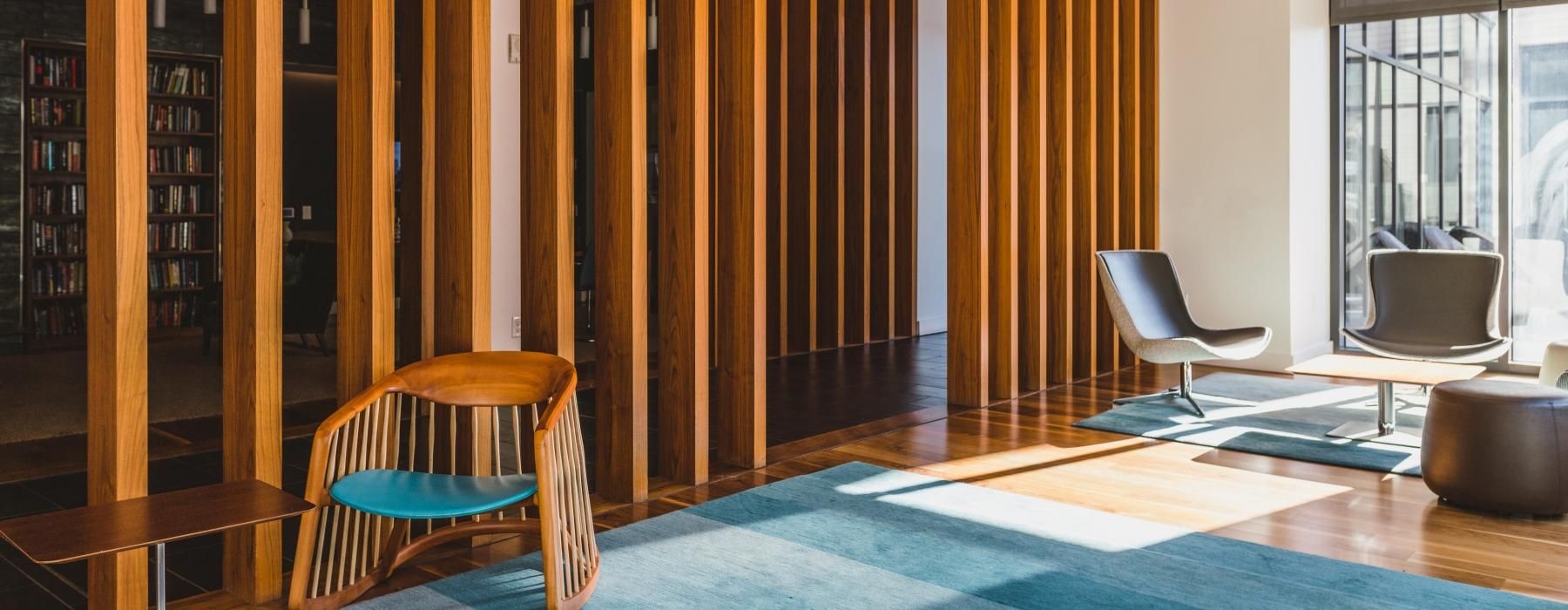 a room with a blue rug and a chair and a table