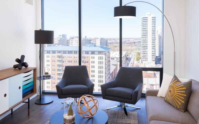 a room with a window and a couch with a table and chairs