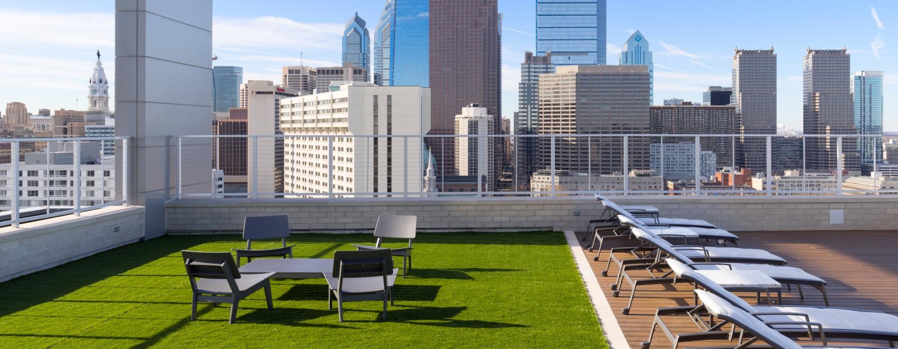 a park with tables and chairs in front of a city skyline